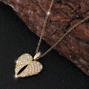 Collier doré en forme d’aile d’ange sertie de strass brillants, posé sur fond noir